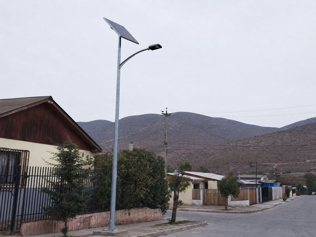 Luminaria solar con panel fotovoltaico montada en un poste sobre una calle residencial